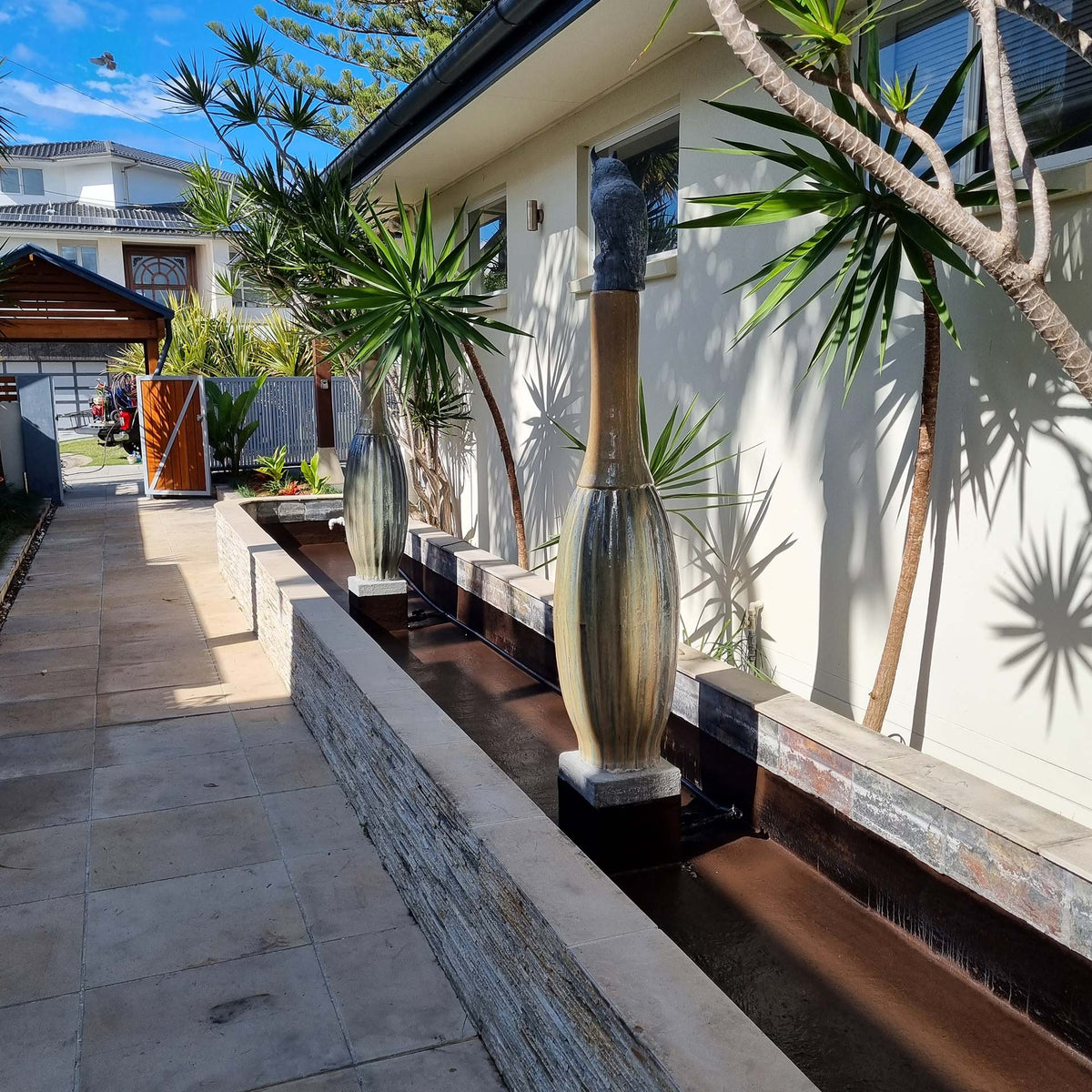 Refurbished outdoor water feature with sealed basin and flowing decorative fountains after waterproofing application